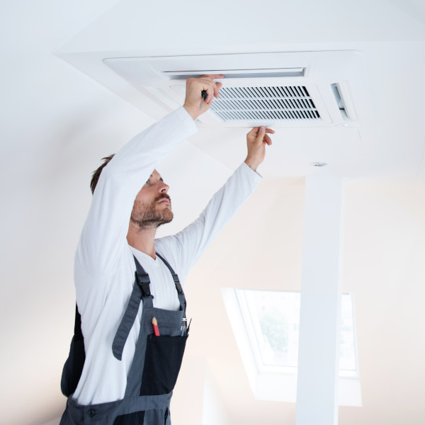 Hausmeister bei der Reparatur einer Klimanalage